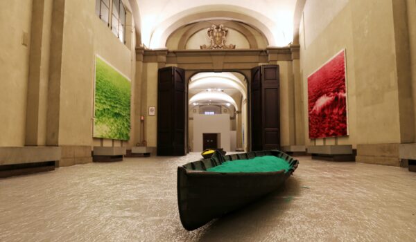 inquadratura dal basso che mostra galleria delle carrozze con barca in primo piano con sabbia verde, alla parete sinistra grande quadro verde, alla parete destra grande quadro rosso